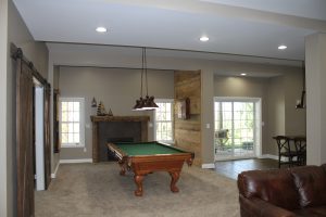 Game area with pool table, ship lap dart board wall and gas fireplace_