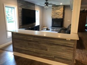 Living area with ship lap, 1_2 wall with granite top and 3-sided stone veneer fireplace