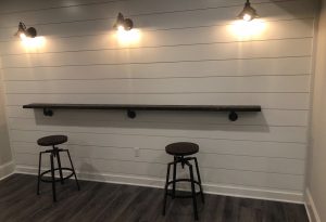 Ship lap wall with scone lights and stained wood work surface