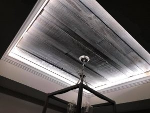 Tray ceiling with barn wood inlay and crown molding with uplighting