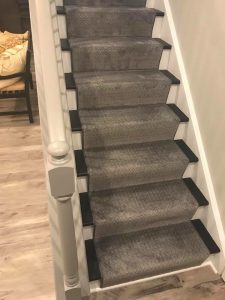 Two tone painted stair treads and risers with runner and stair railing