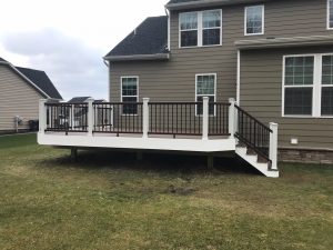 White fascia and railing posts with vintage lantern railing, black aluminum balusters and Spiced Rum decking