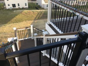 White railing with black round aluminum balusters and 2x4 Spiced Rum cocktail top